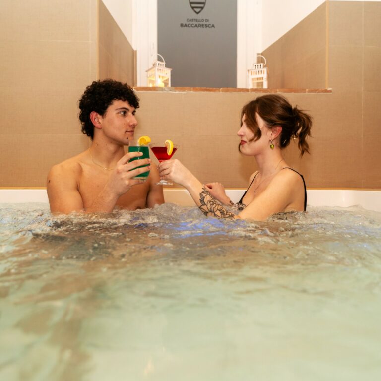 coppia di persone che brinda e si rilassa nella jacuzzi del castello di baccaresca