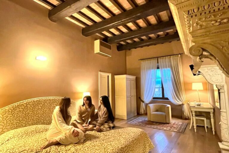 junior suite con travi a vista camino monumentale e ospiti nel letto della camera
