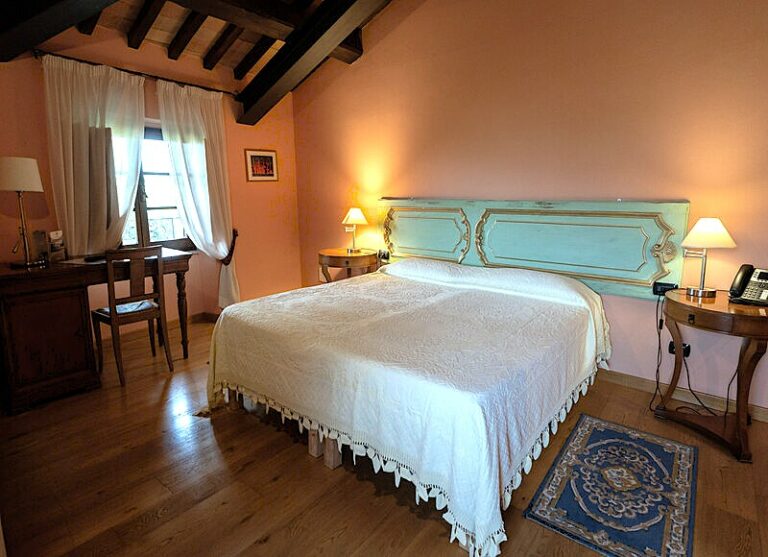 Interni della tower suite con contrasto muro rosa e letto verde acceso