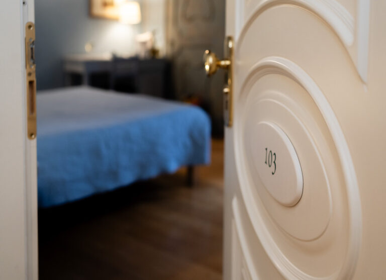 Camera classic del castello di baccaresca gubbio con porta su scritto 103 e letto in sottofondo