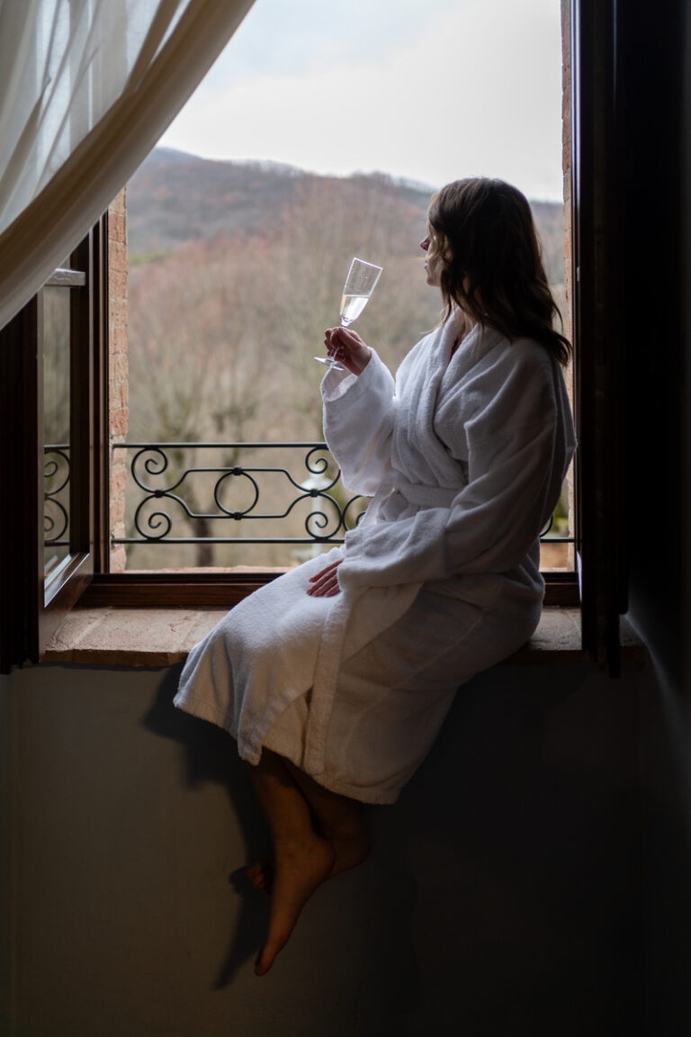 Ragazza che sorseggia un calice appoggiata ad una finestra della camera del castello di baccaresca a gubbio