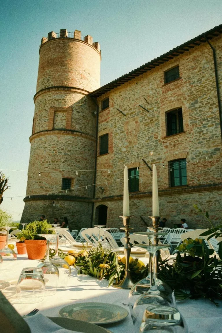Allestimento tavoli nuziali all'aperto in stile mediterraneo con limoni e candelabri presso il Castello di Baccaresca a Gubbio.
